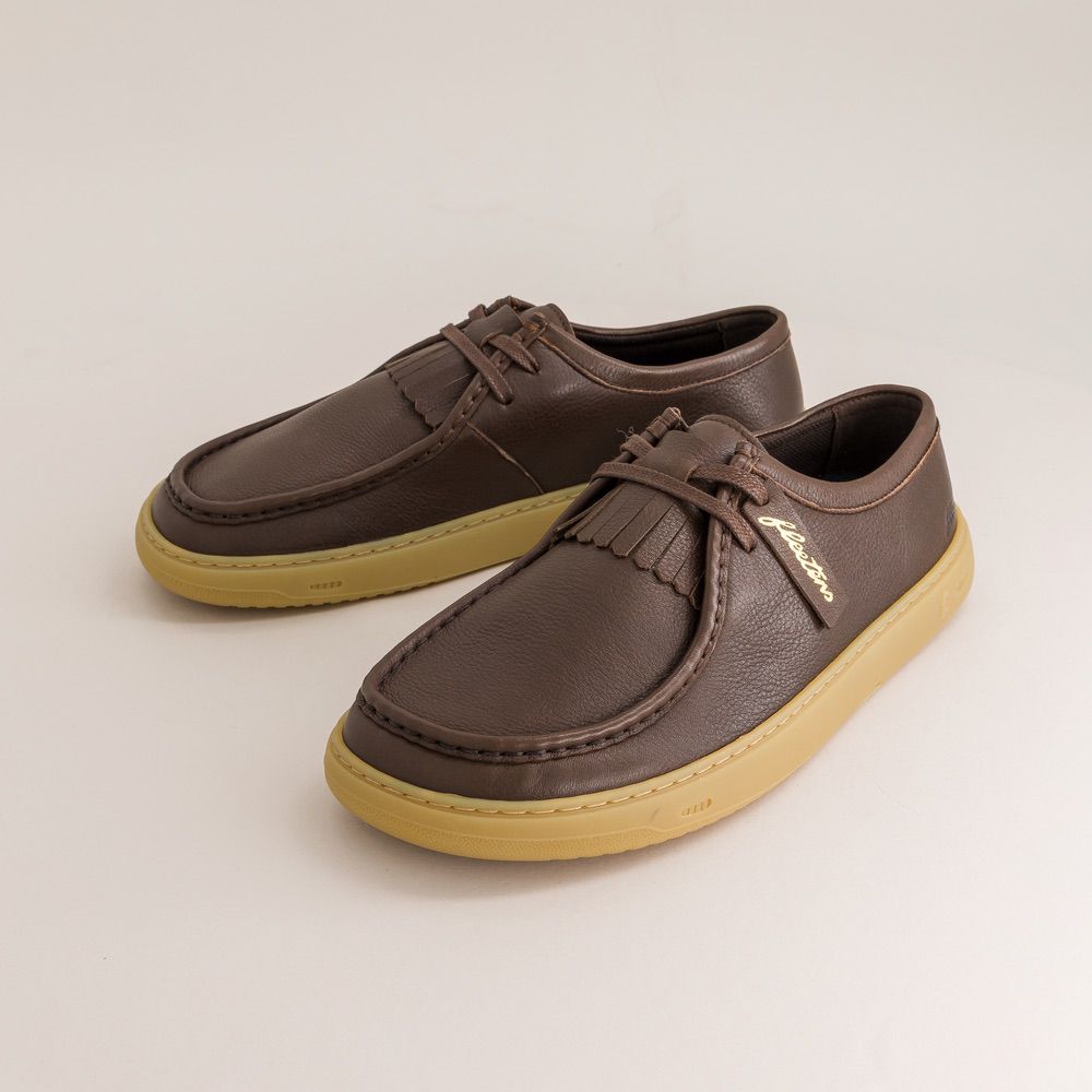 Pair of brown leather barefoot derbies with yellow soles on a light beige background
