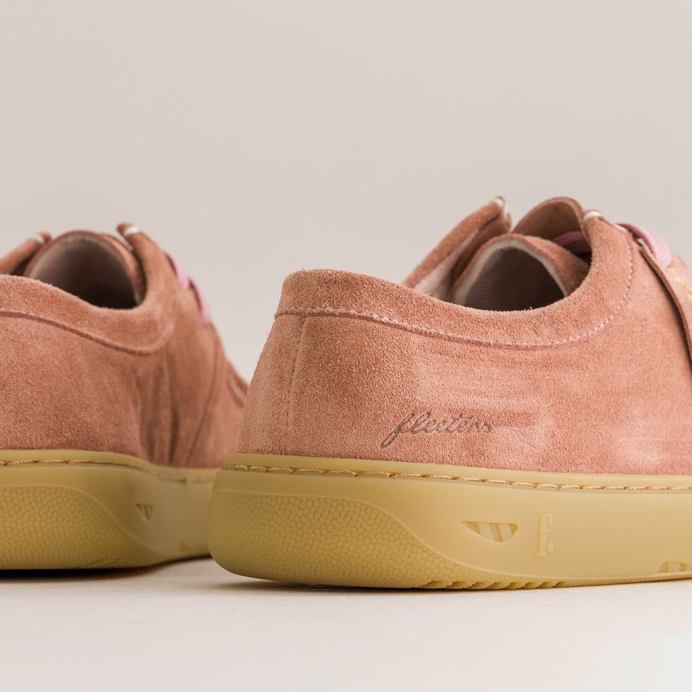 Pair of pink suede barefoot derbies with yellow soles on a light background