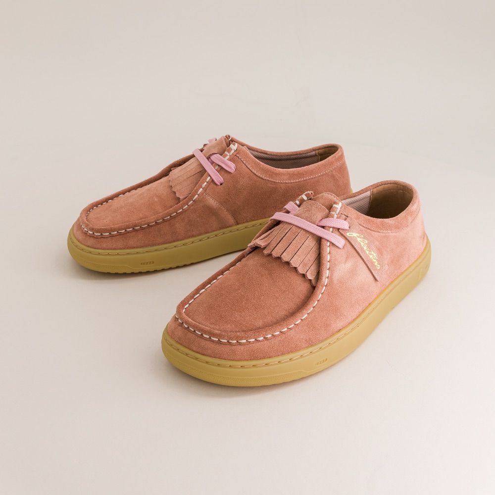 Pair of pink suede barefoot derbies with yellow soles on a light beige background