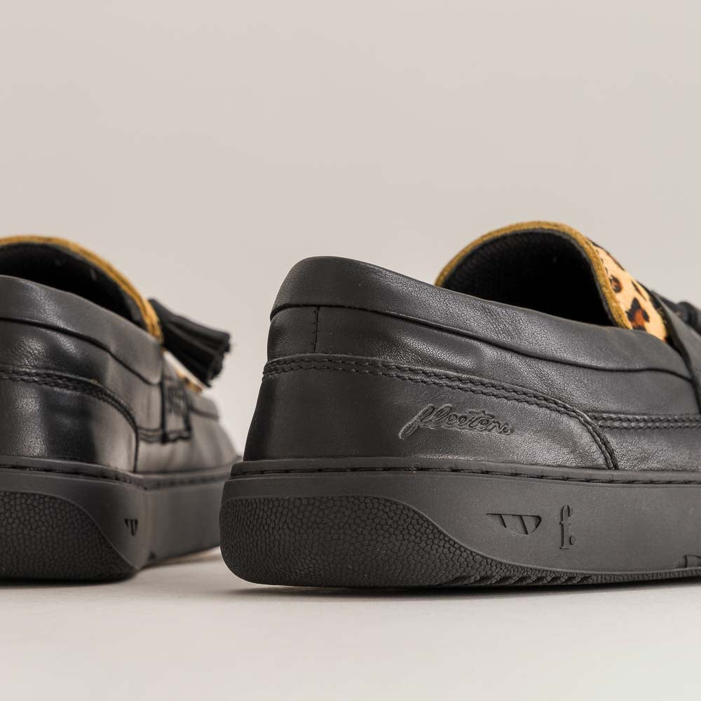 Black leather barefoot shoes with brand logo on a light gray background