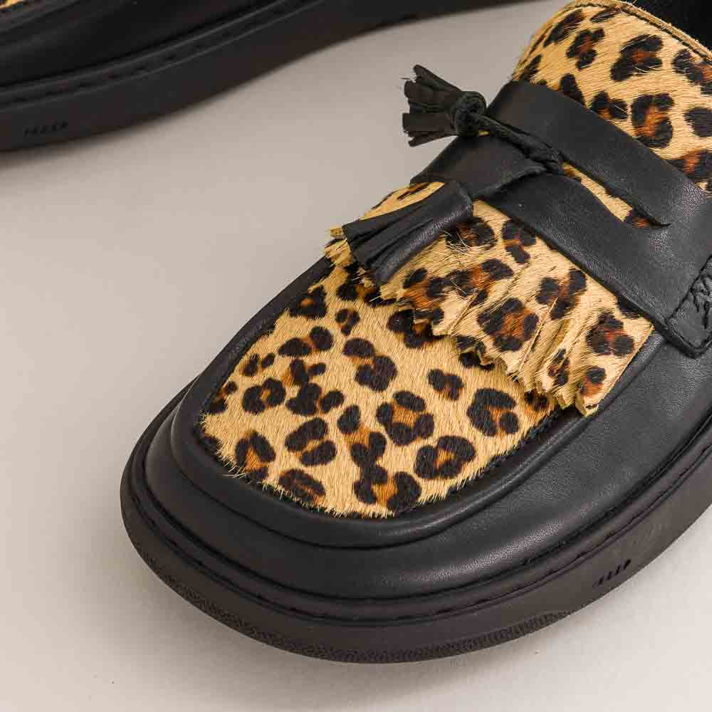 Leopard print shoe with black sole on a light background