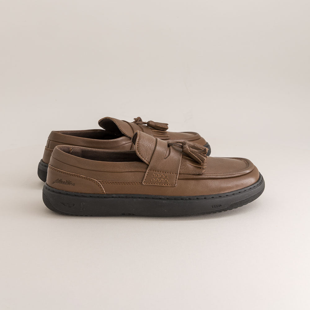 Brown leather barefoot shoes with a bow on a light beige background