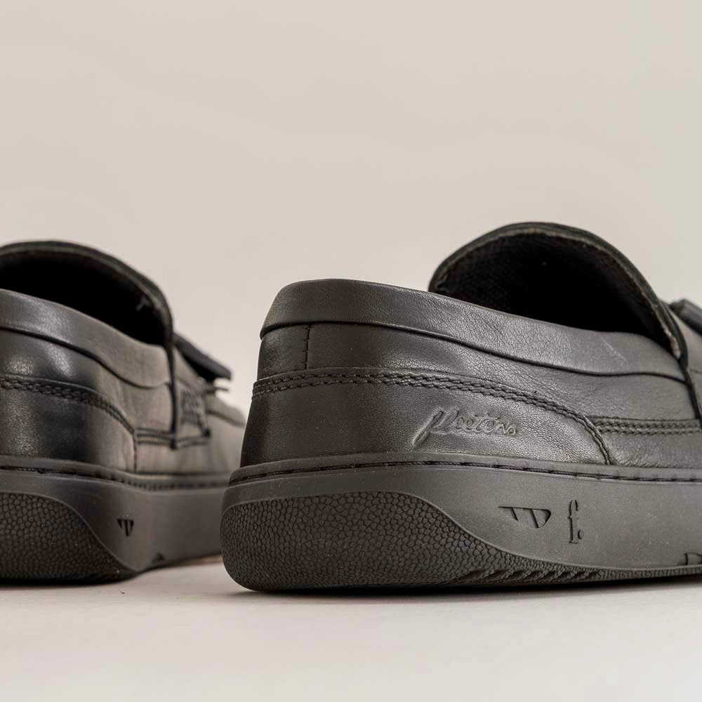 Pair of black leather shoes on a neutral background