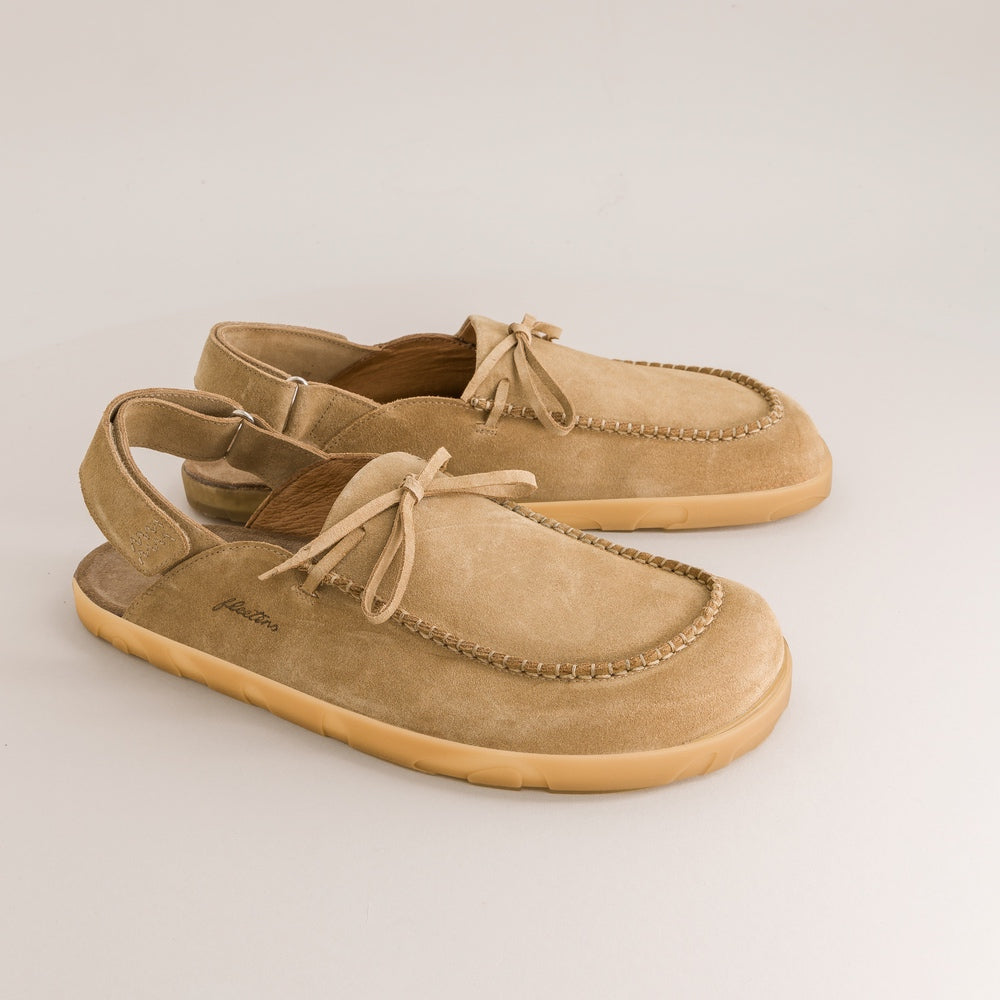 Pair of tan barefoot mules on a light gray background