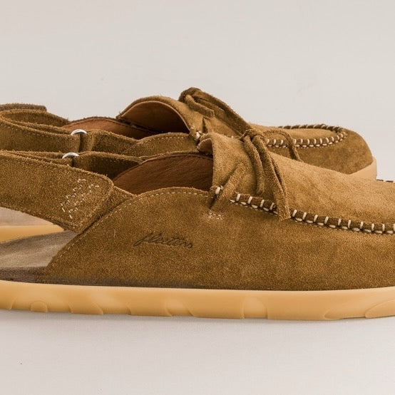 Brown suede barefoot mules with tan soles on a light gray background