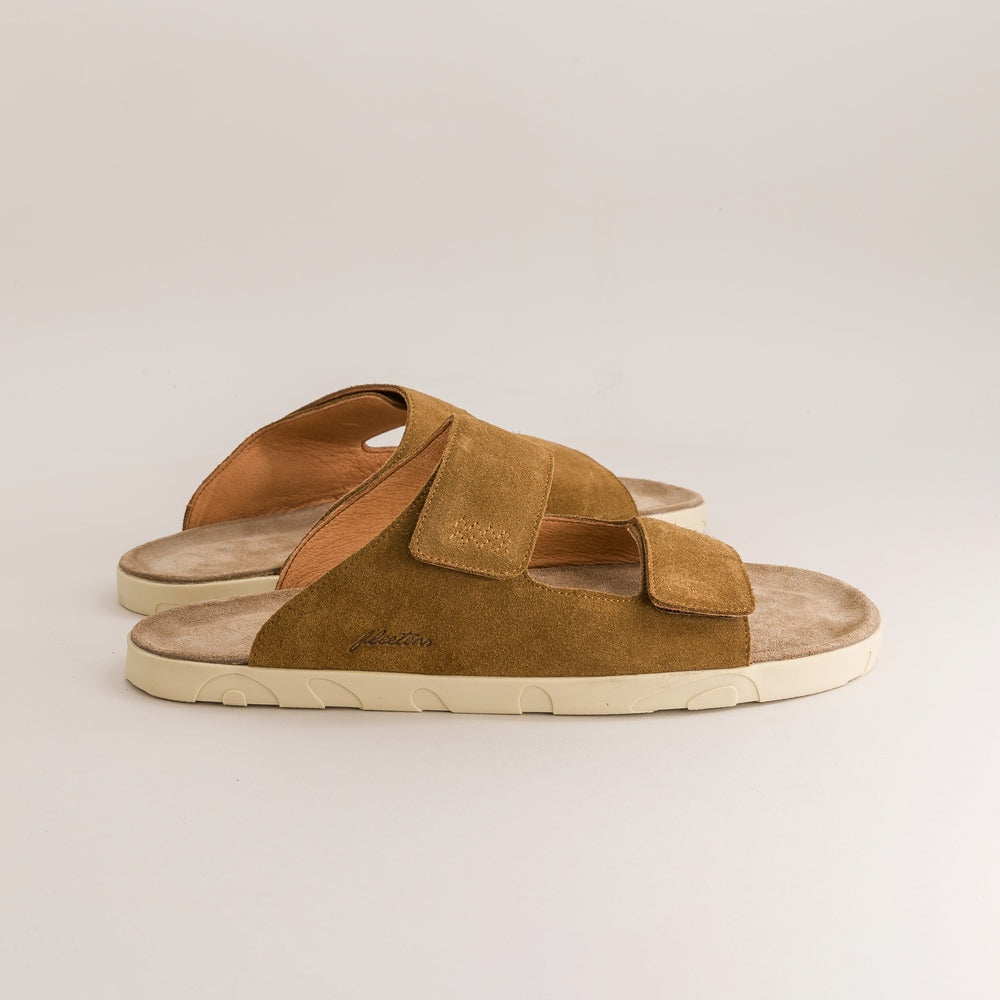 Pair of brown barefoot sandals with a white sole on a light gray background