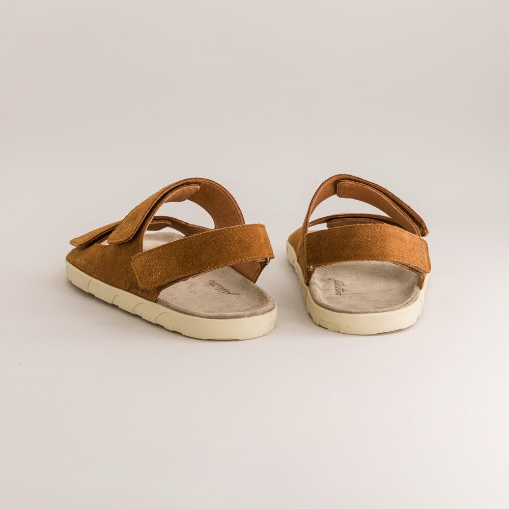 Pair of brown barefoot sandals on a light gray background