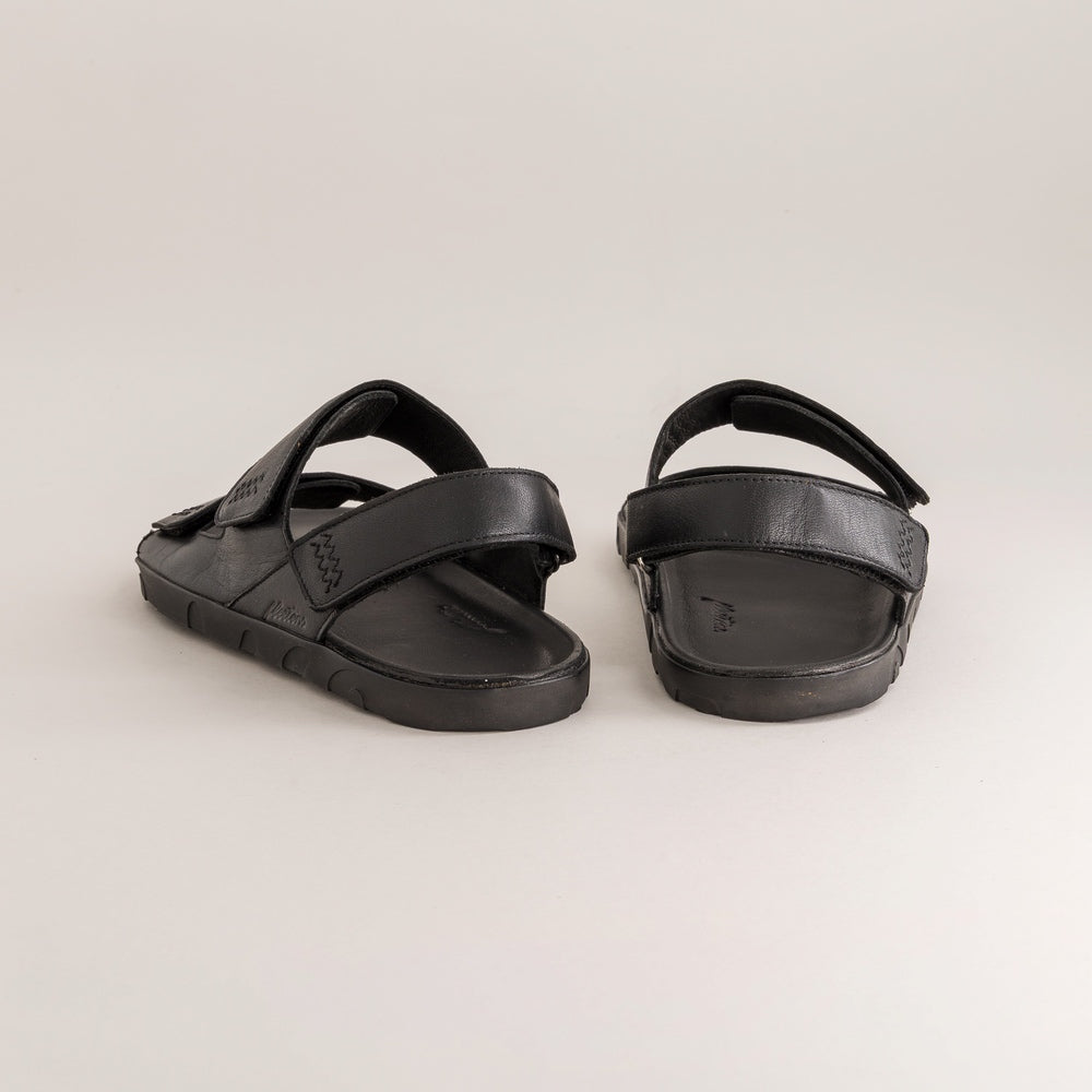 Pair of black barefoot sandals on a light gray background