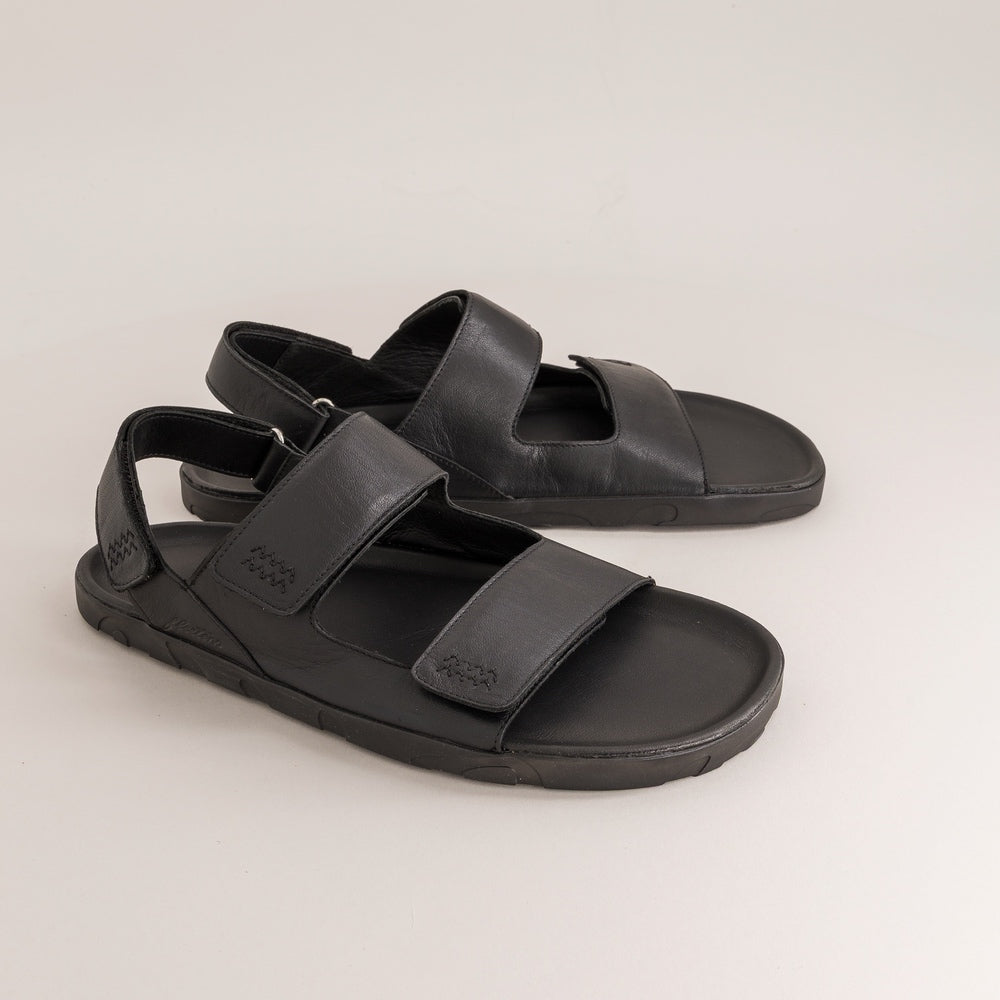 Pair of black barefoot sandals on a light gray background