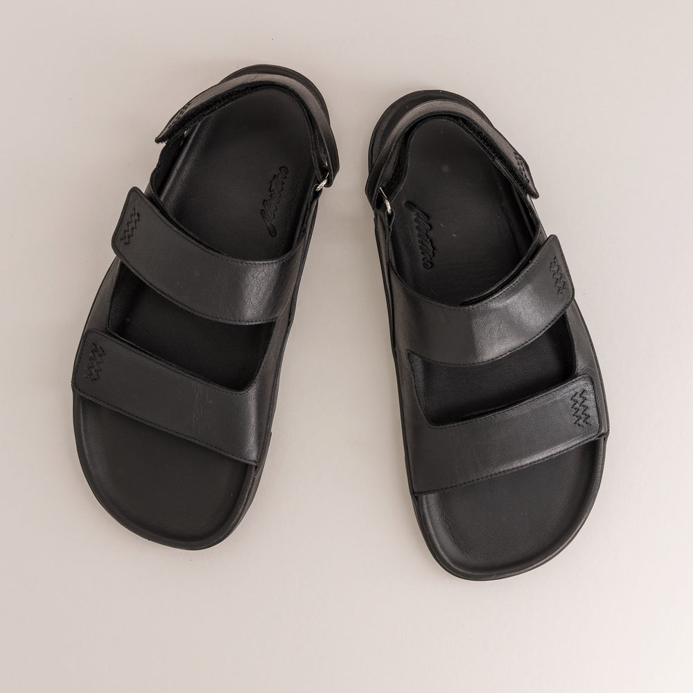 Pair of black barefoot sandals on a light gray background