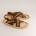 Pair of brown barefoot sandals with leopard print straps on a light gray background