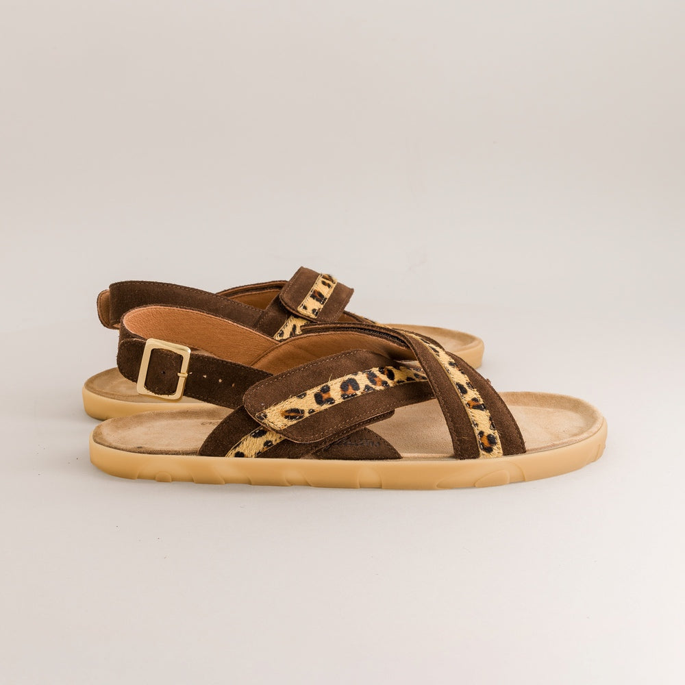 Brown barefoot sandals with leopard print straps on a light gray background