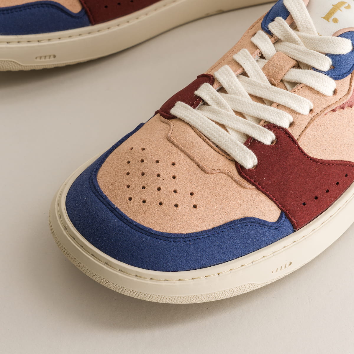 Close-up of a multicolored barefoot sneaker with white laces on a light background