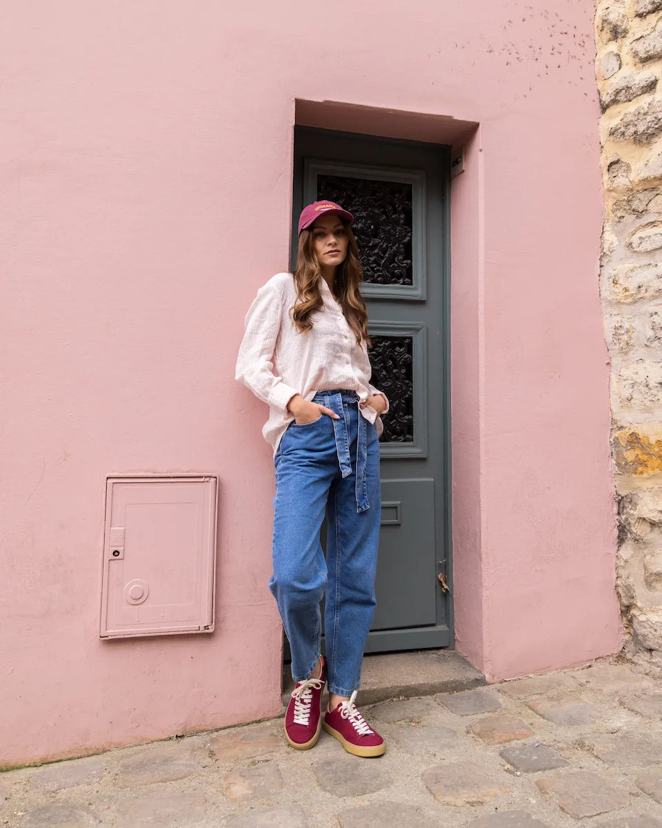 Woman standing in front of a pink wall with a gray door
