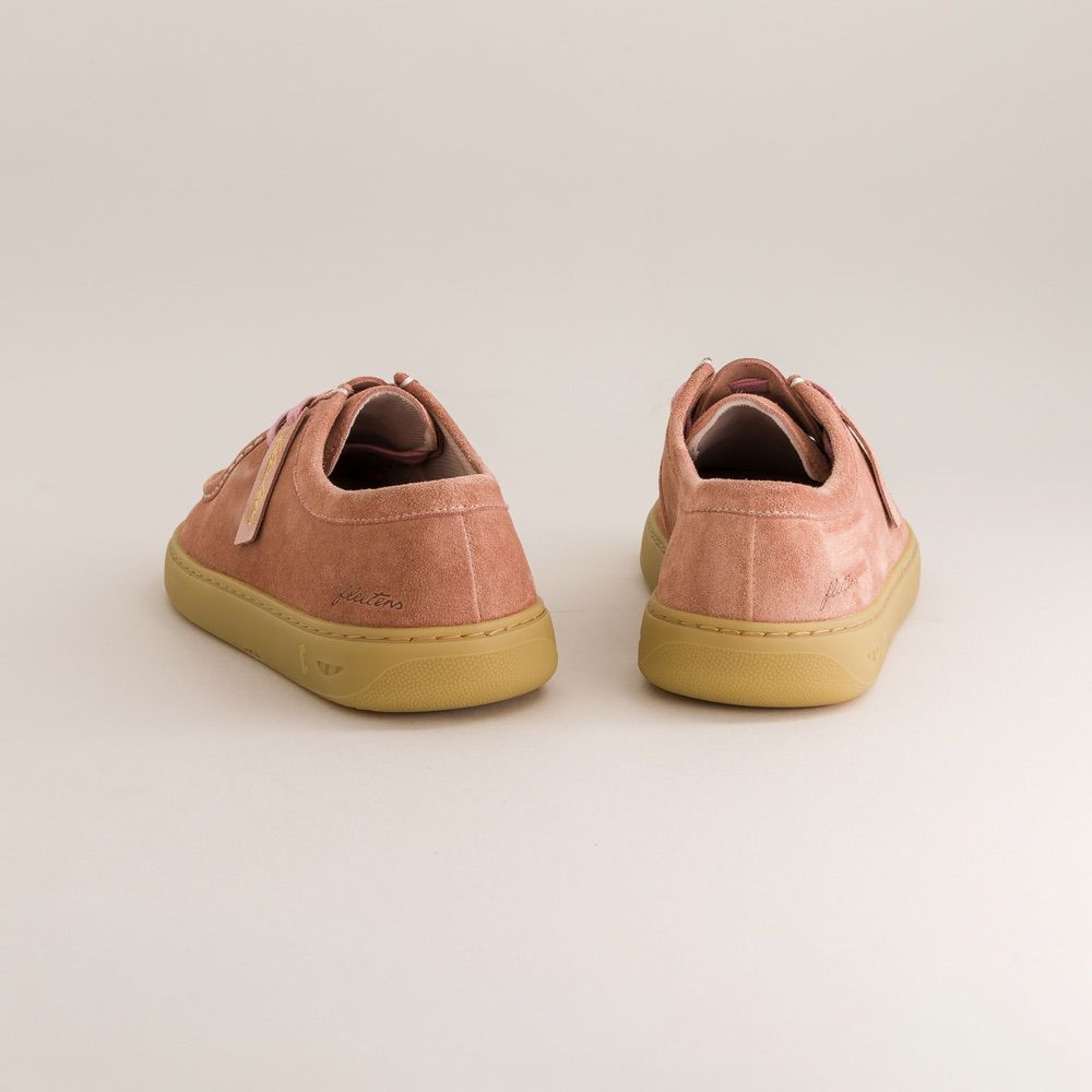 Pair of pink barefoot derbies with yellow soles on a light beige background
