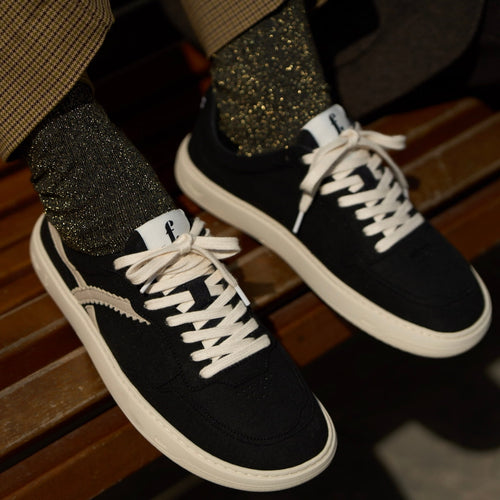 person wearing black barefoot sneakers 