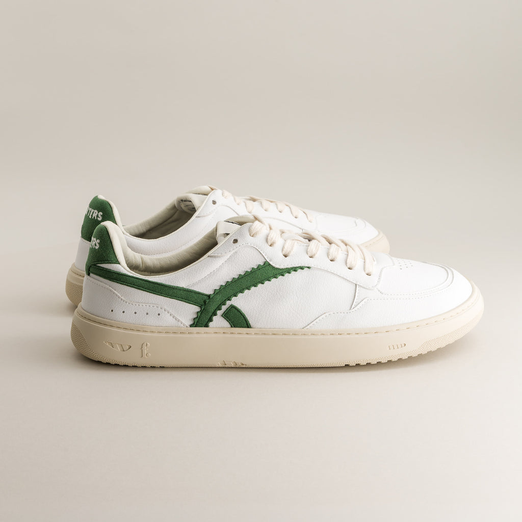 White barefoot sneakers with green accents on a light gray background 