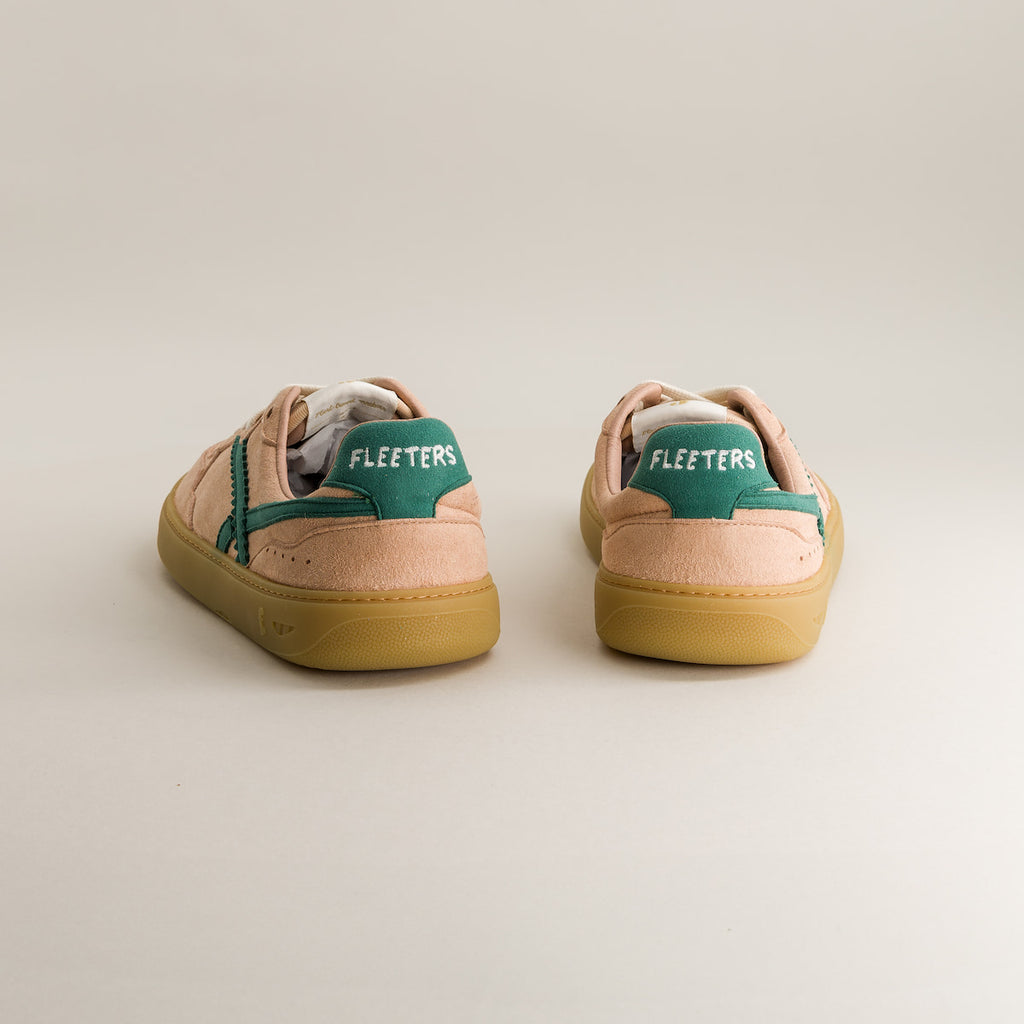 Pair of barefoot sneakers with green accents on a light gray background