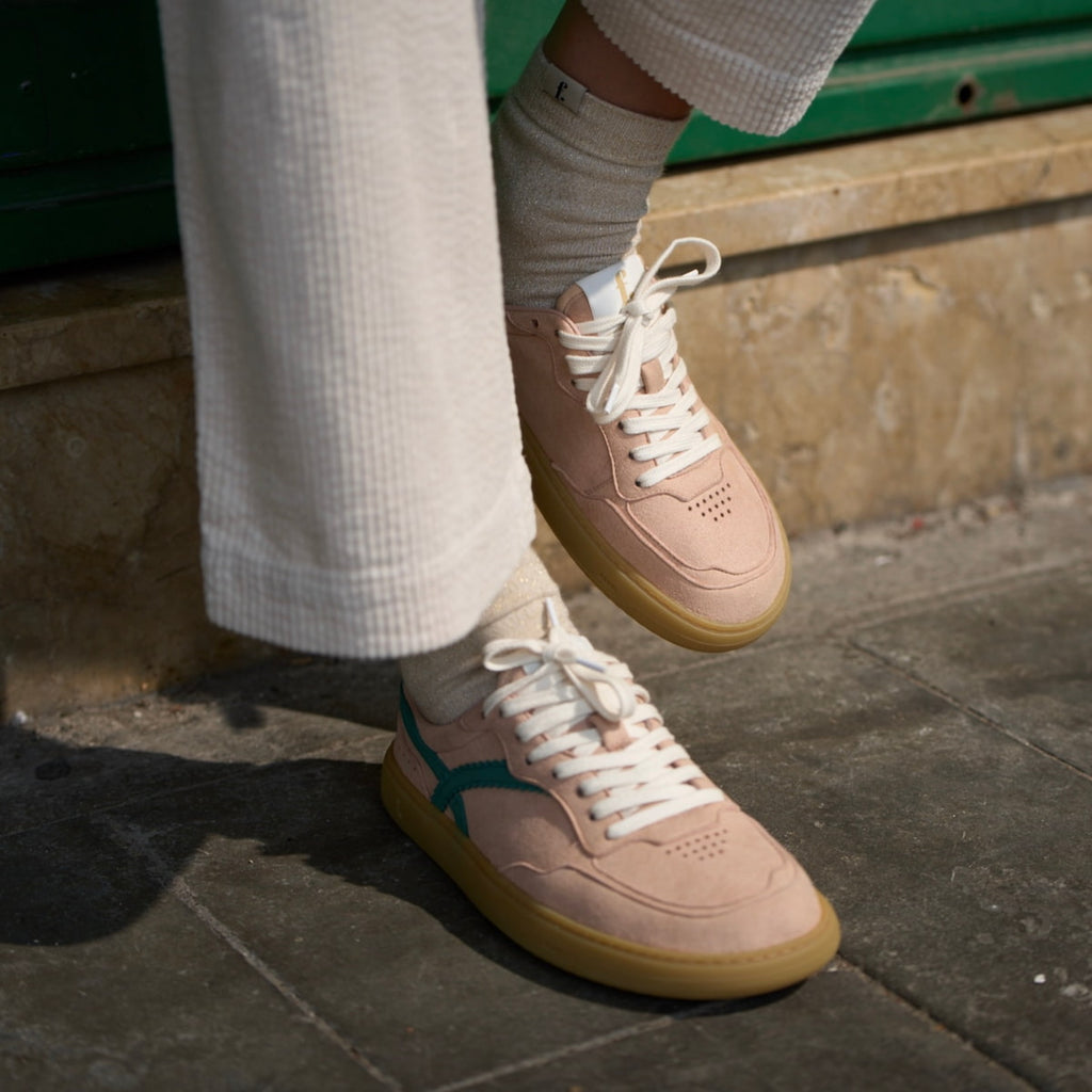 Person wearing pink barefoot sneakers with white laces