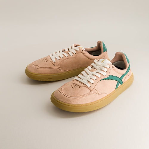 Pair of pink barefoot sneakers with white laces on a beige background