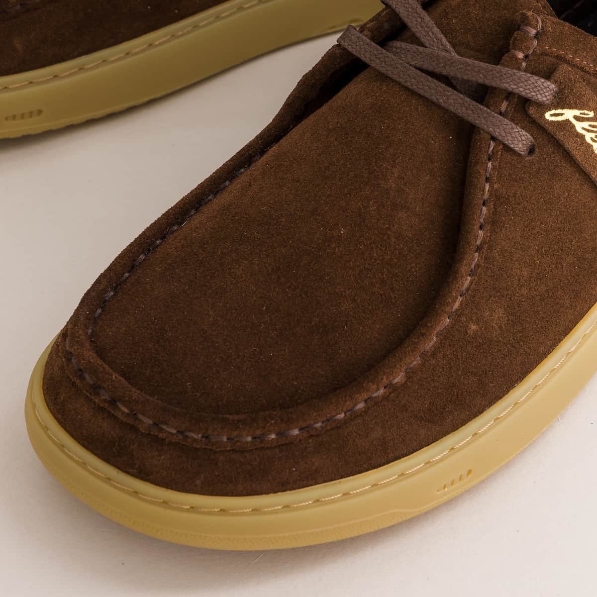 Brown suede derby shoe with a light brown sole on a white background