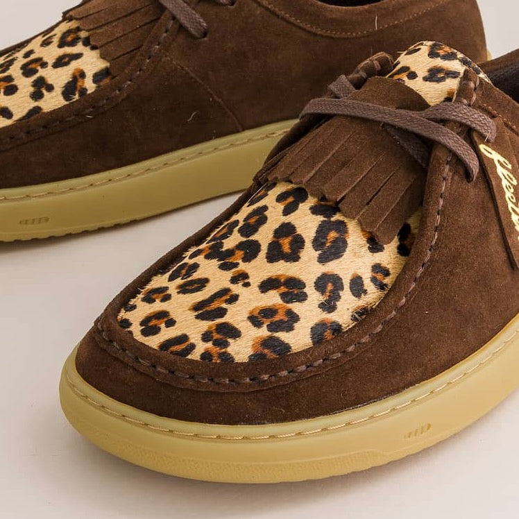 Brown suede derby with leopard print soles on a light background