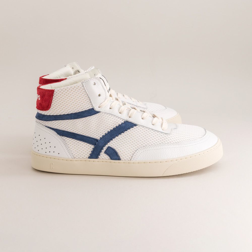 White sneaker with blue and red accents on a light gray background