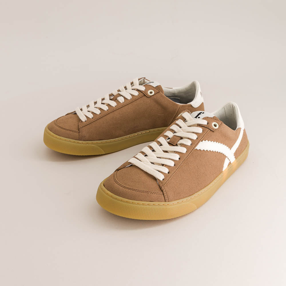 Pair of brown barefoot sneakers with white laces on a light gray background