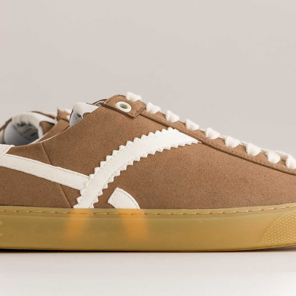 Brown  barefoot sneaker with white accents on a gray background