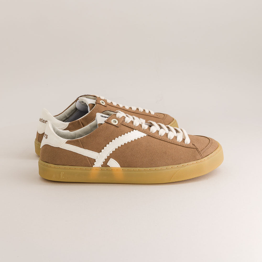 Brown  barefoot sneakers with white laces on a beige background