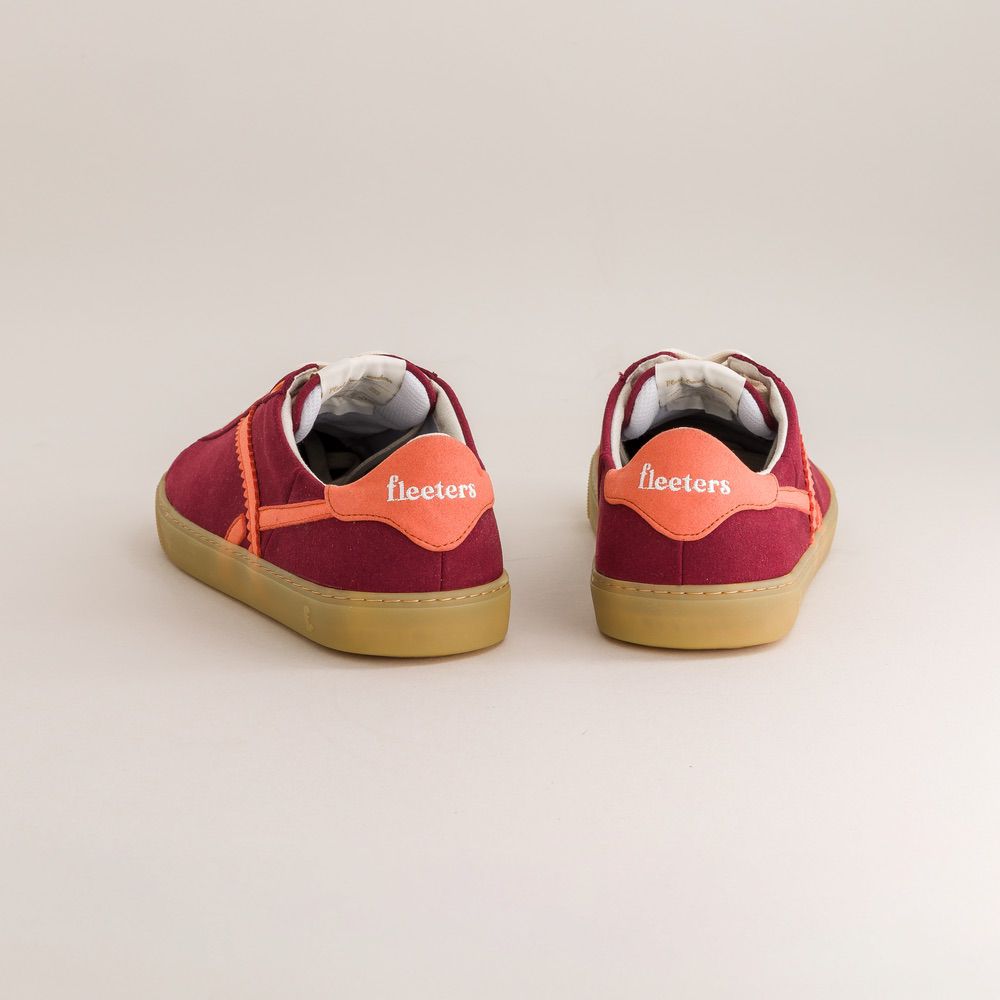 Red barefoot sneakers with orange accents on a light gray background