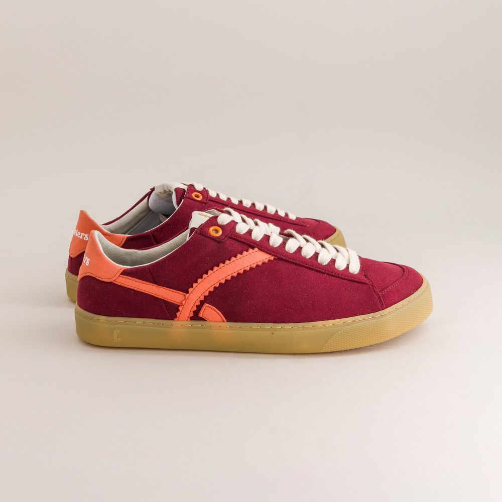 Red barefoot sneakers with orange accents on a light gray background