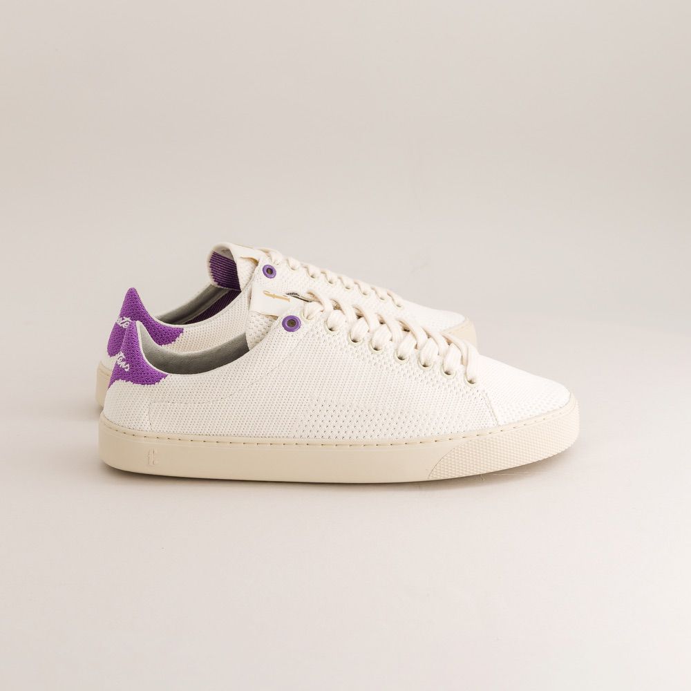 White knit barefoot sneaker with purple accents on a light gray background