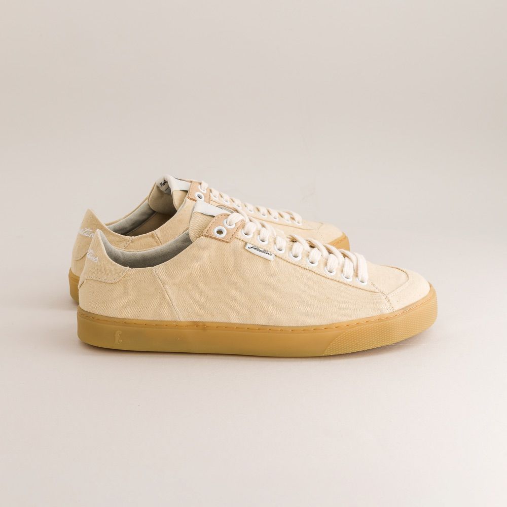 Beige barefoot sneakers with white laces on a light beige background