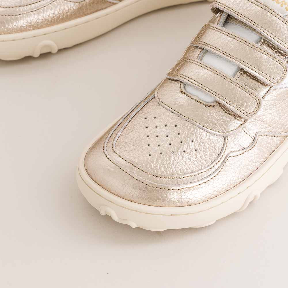 Close-up of a beige kids barefoot sneaker on a light background