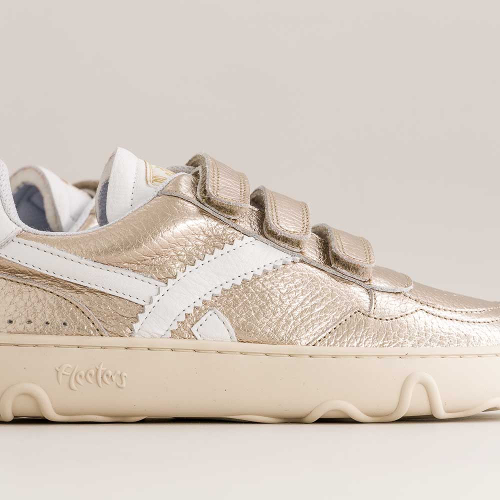 Gold and white kids barefoot sneaker with a visible brand logo on a light gray background