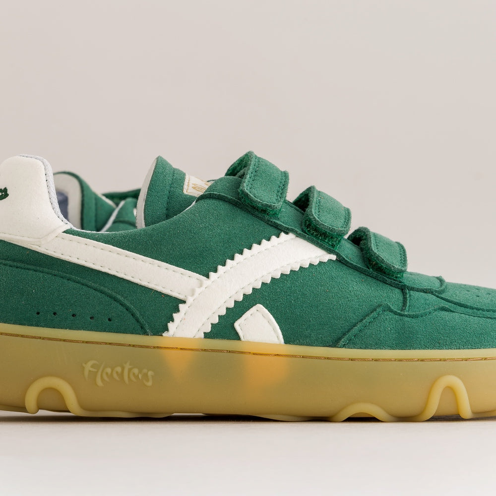 A green suede and canvas low-top sneaker with white side stripes, three hook-and-loop straps, and a translucent gum sole. The word 'Fleeters' is embossed on the side of the sole.