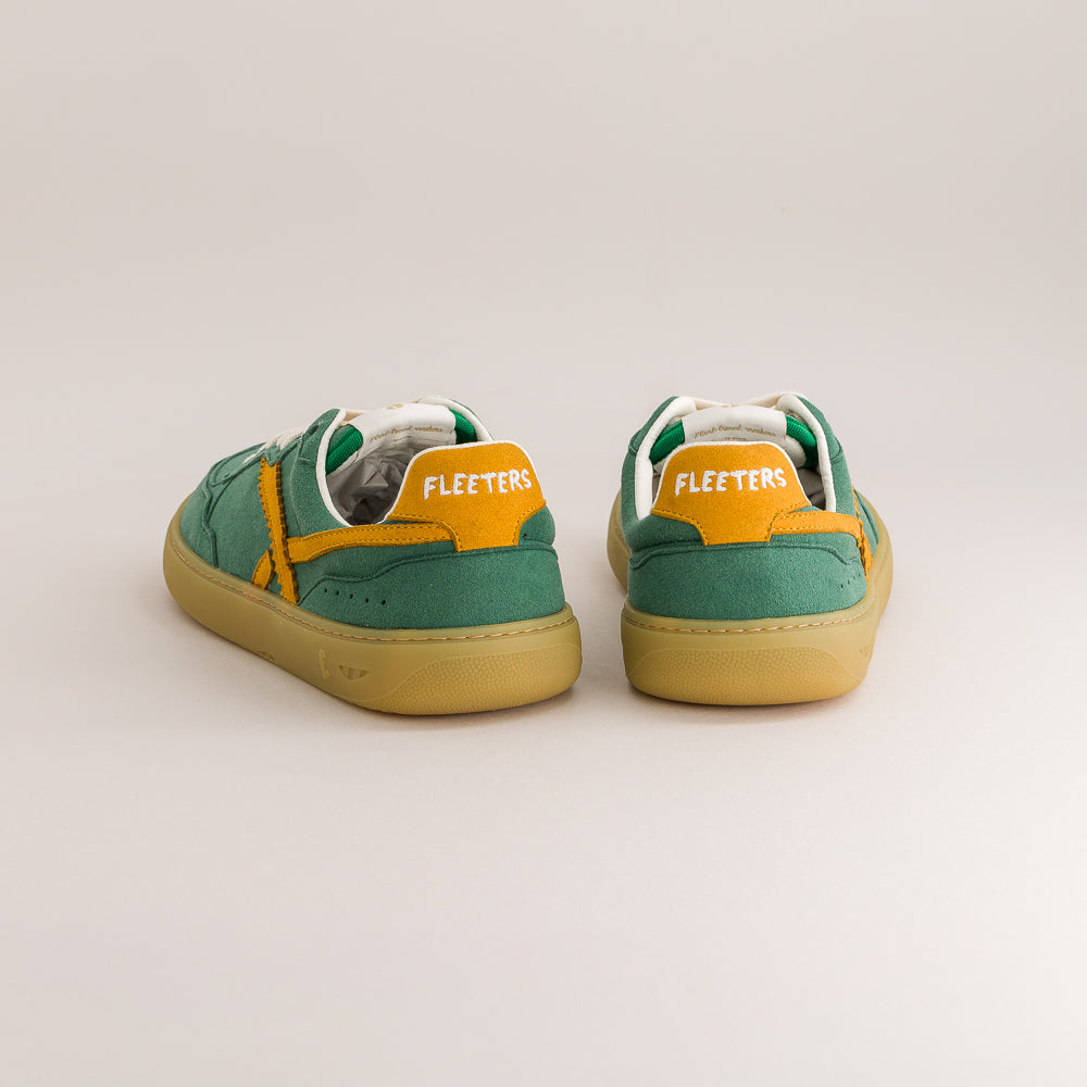 A pair of green and yellow suede sneakers shown from the back on a light gray studio background. The shoes feature a green suede upper, a bright yellow heel tab with 'FLEETERS' in white text, and a tan gum sole.