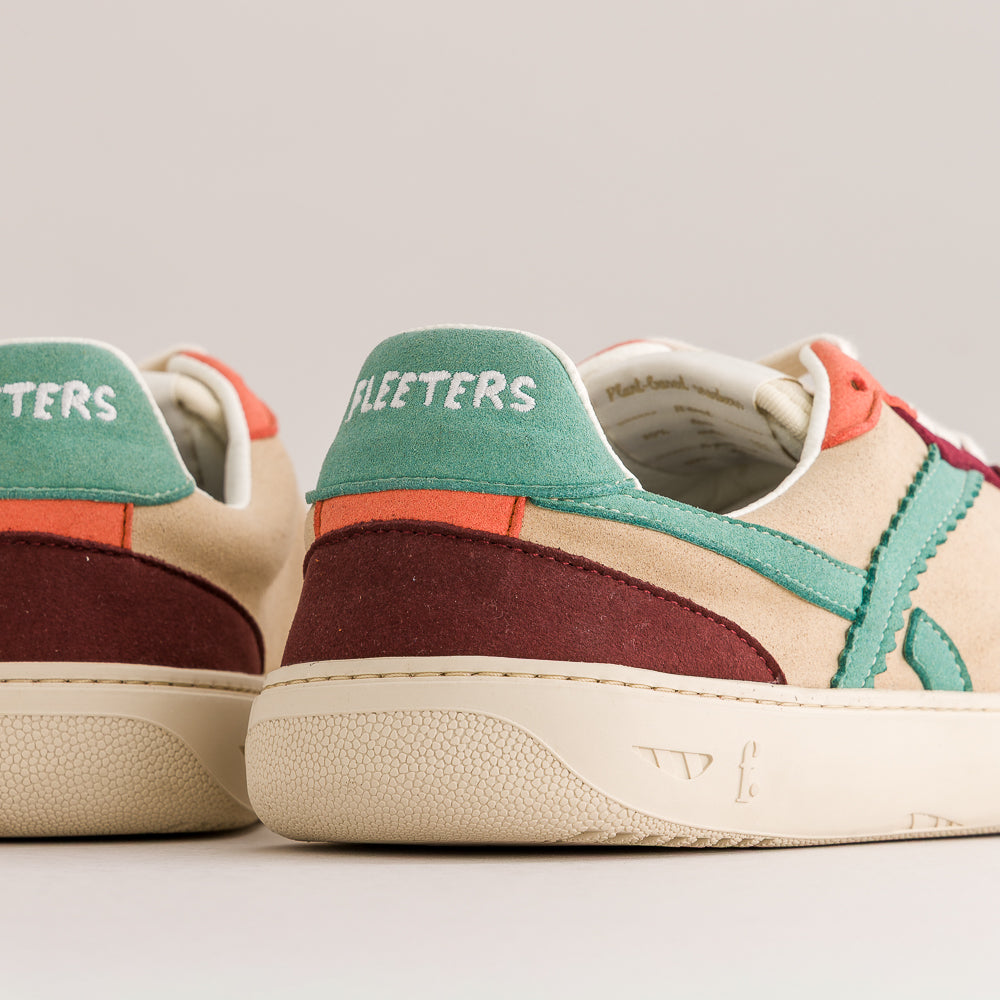 Close-up rear three-quarter view of a pair of suede sneakers. The shoes feature a beige suede upper, a teal green heel tab with white 'FLEETERS' branding, a dark burgundy suede heel panel, and a coral-pink stripe detail.