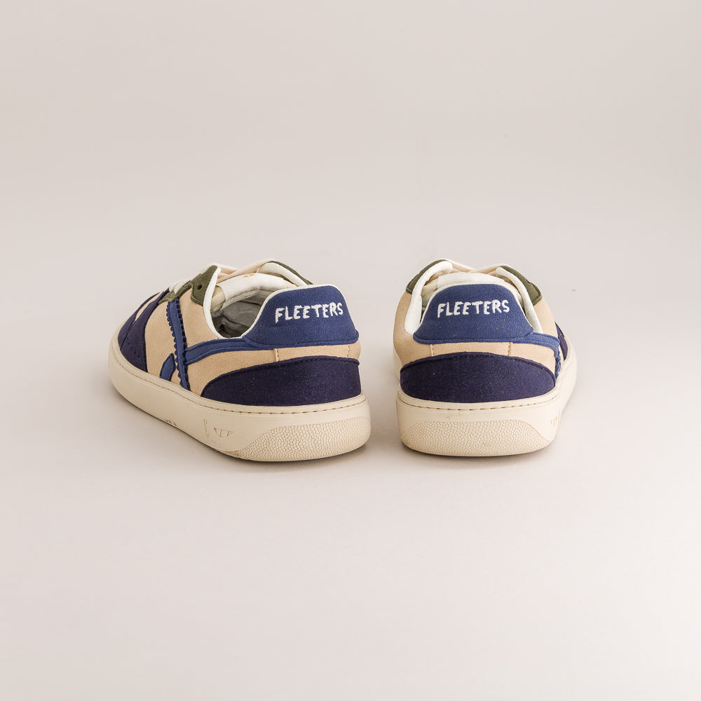 A pair of Fleeters low-top sneakers shown from the back, featuring navy blue suede panels, cream canvas overlays, and cream rubber soles on a light beige background.