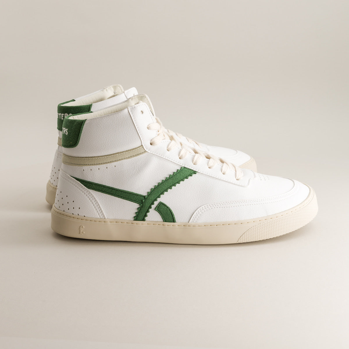 White high-top barefoot sneakers with green accents on a light gray background