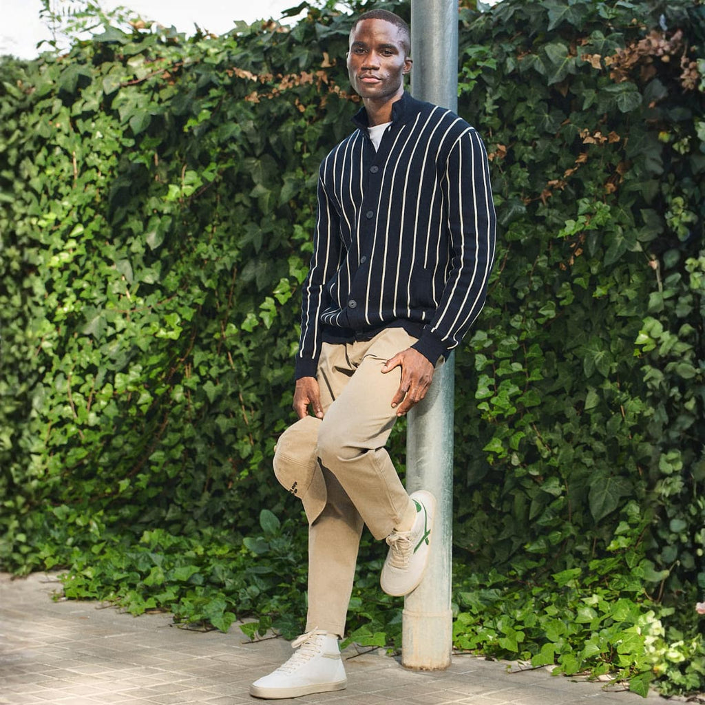 man wearing White high-top barefoot sneakers with green accents 