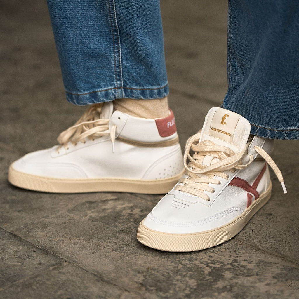 person wearing a Pair of white mid-ankle barefoot sneakers with pink accents 