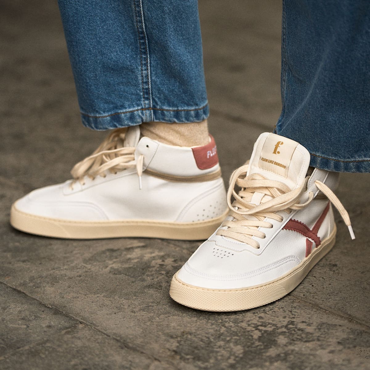 person wearing a Pair of white mid-ankle barefoot sneakers with pink accents 