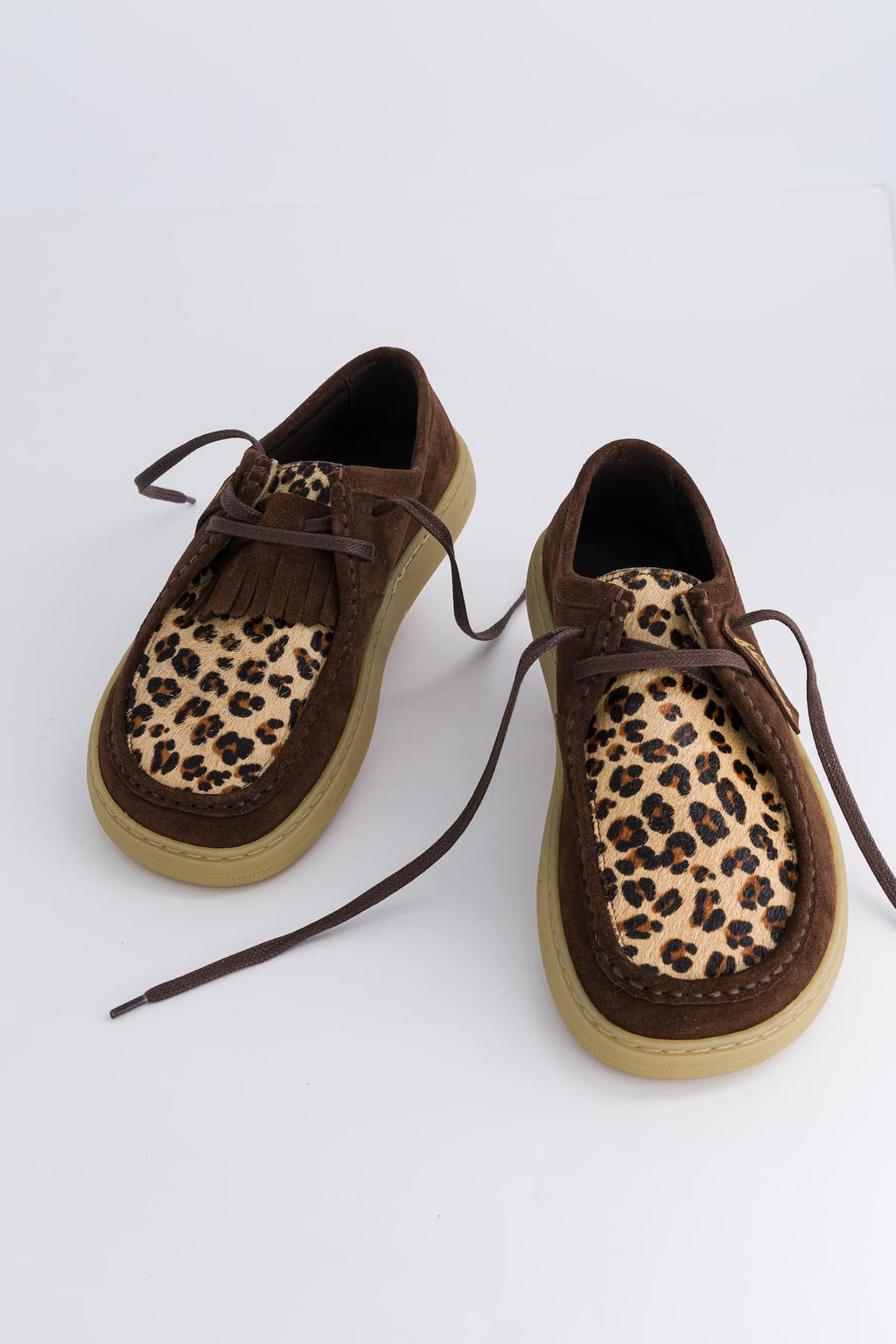 Brown shoes with leopard print soles on a white background