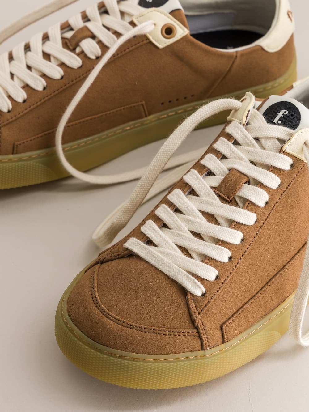 Brown minimalist sneakers with white laces on a light background